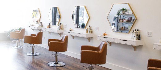 A bright salon with styling chairs, large mirrors and a clean floor